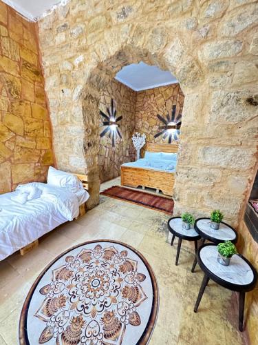 达纳DanaBlack iris house的一间卧室设有石墙、一张床铺和桌子。