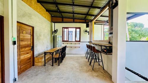 涛岛Koh Tao Silver Na’s Hostel的厨房以及带桌椅的用餐室。