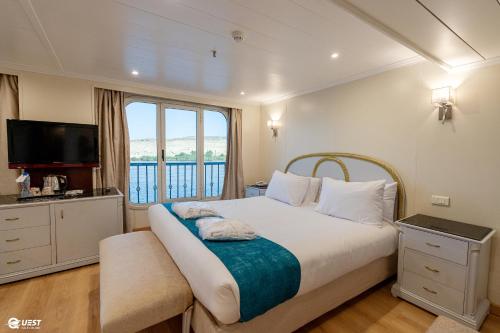 卢克索M/S Nile Quest Cruise - 4 or 7 Nights From Luxor each Monday and 3 or 7 Nights From Aswan each Friday的一间卧室设有一张大床和一个窗户。