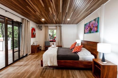 比加瓜Sueño Río Celeste Boutique B&B的一间卧室设有一张带木制天花板的大床