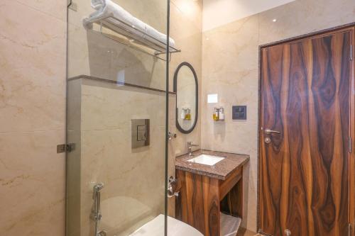 德拉敦Hotel Lalit Palace的带淋浴、卫生间和盥洗盆的浴室