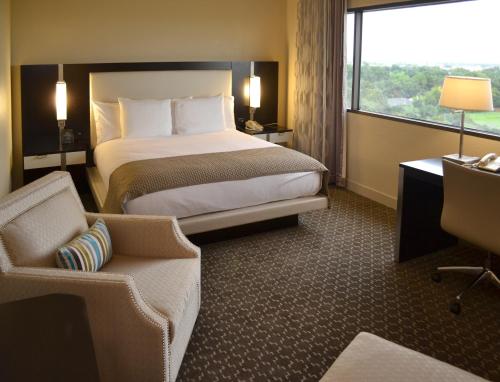 休斯顿休斯顿霍比机场希尔顿酒店的酒店的客房 - 带一张床、椅子和窗户