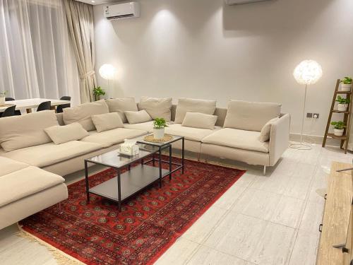 利雅德الرياض البوليفارد شقق عبيه Vip الفاخره的客厅配有沙发和桌子