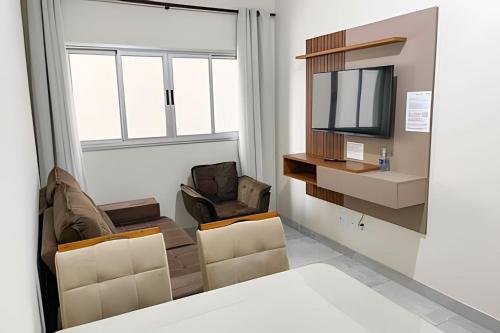 帕图斯迪米纳斯104 - Apartamento Completo para até 7 Hóspedes的客厅配有两把椅子和电视