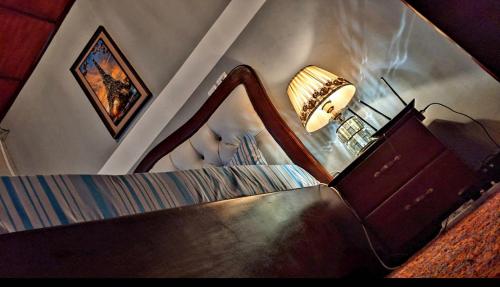 杜阿拉RAMS ENG ROME appartement meublé的一间卧室配有镜子、灯和床