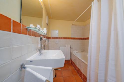 德累斯顿坎帕尼奥拉膳食公寓及餐厅的浴室配有盥洗盆和浴缸。