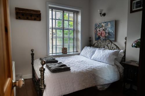 哈沃斯The Little Hideaway - Historic Gem off Haworth Main Street的一间卧室配有一张带白色床单的床和一扇窗户。