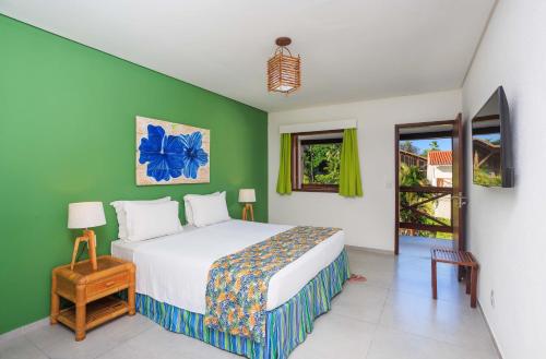 嘎林海斯港Armação Resort Porto de Galinhas的一间卧室设有一张床和绿色的墙壁