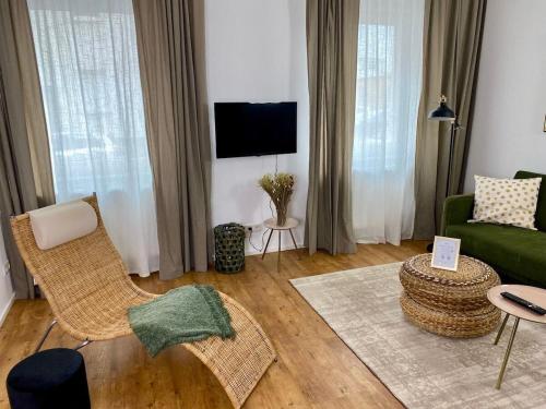 艾森纳赫discovAIR Eisenach - 3-Zi- Apartment Matteo- Schwimmbad-Nah mit Netflix的客厅配有绿色沙发和椅子