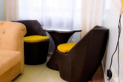 内罗毕Garden estate thika road的两张带黄座椅的柳条椅,毗邻桌子