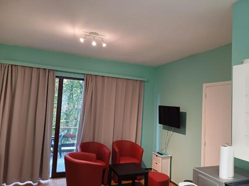 WaulsortHoliday Cottage的客厅配有红色椅子和电视