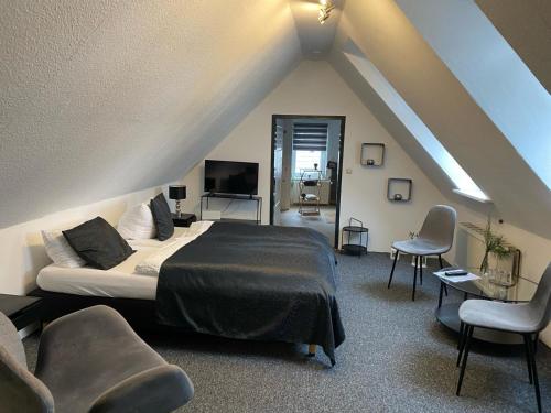 戈斯拉尔艾尔特斯德-吉奥斯克尔酒店的阁楼上一间卧室配有床和椅子