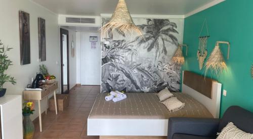 圣吕斯Couleur caraïbes appartement dans un hôtel 3 étoiles vue mer的客厅配有沙发和壁画