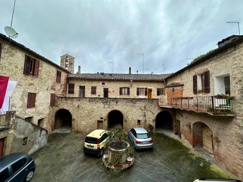 阿夏诺La casina nel convento的两辆汽车停在一座建筑的庭院里