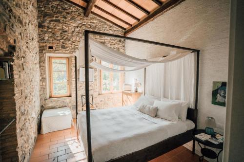 卡夏纳泰尔梅乐瓦利农场酒店的卧室配有一张位于砖墙的天蓬床