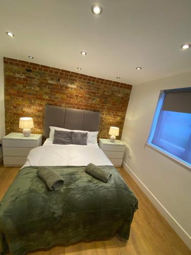 BansteadStudio apartment near Sutton, Croydon的一间卧室配有一张带2个床头柜的大床