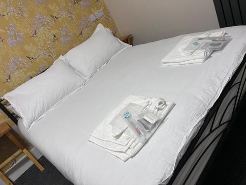 汤顿Woolaway 2的一张带白色毛巾和一对剪刀的床
