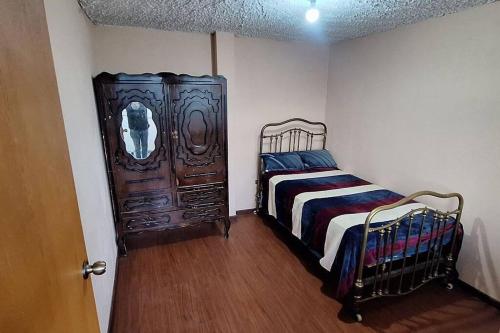 奥塔瓦洛Casa y mirador的一间卧室配有一张床和一个木制橱柜