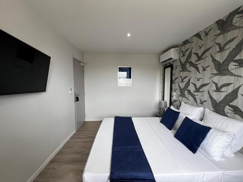 卡宴Chambre Selva的卧室配有带蓝色枕头的大型白色床