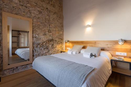 Pinell de BrayCasa Rural Boutique Ca Bolo的一间卧室设有一张大床和石墙