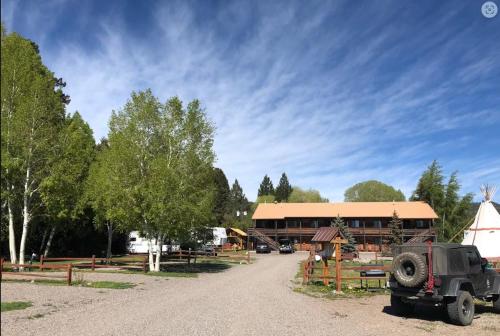 南福克Ute Bluff Lodge, Cabins and RV park的停在大楼前的吉普车