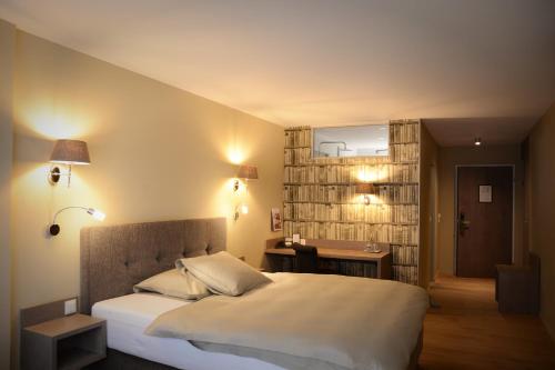 朗根塔尔朗根塔尔公园酒店的一间卧室配有一张床、一张书桌和一面镜子