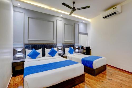 孟买Hotel Gorrion的两张位于酒店客房的床,配有蓝色枕头