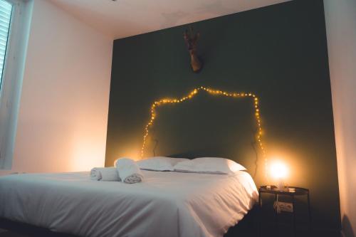 图尔Le Chenin T2 pour 4 personnes的卧室配有一张挂在墙上的灯光床。