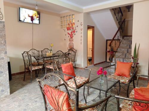科帕卡巴纳Villa Bella Copacabana的用餐室配有桌子、椅子和橙色枕头