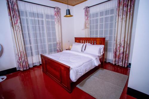 莫希Royal Homestay的一间卧室设有一张床和两个大窗户
