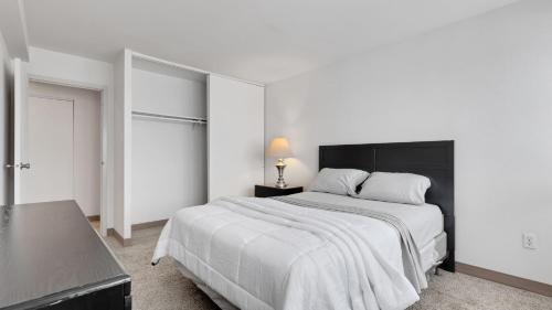 哈里斯堡Corporate 1br Suite, Pool, Free Parking, Gym Pp的白色卧室配有一张大床和黑色床头板