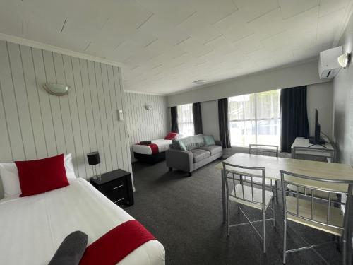 旺阿雷肯辛顿汽车旅馆的酒店客房配有床、桌子和沙发。