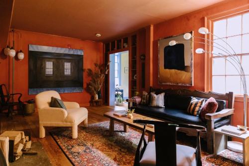 米斯蒂克Eileen of Mystic的客厅设有橙色墙壁、沙发和桌子