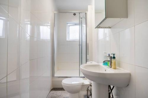 伦敦Hatton Homes - Thackeray Avenue的白色的浴室设有水槽和卫生间。