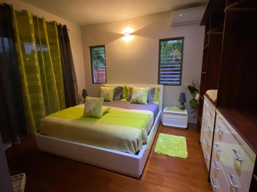 MahinaVilla Ora Na的一间卧室配有一张带绿色床单的床和窗户。