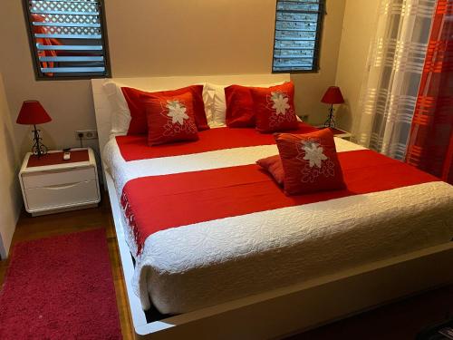 MahinaVilla Ora Na的一间卧室配有一张带红色枕头的大床