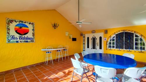 普拉亚科罗纳多Las Catalinas Coronado的一间配备有蓝色桌子和椅子的用餐室