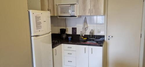 阿瓜斯克拉腊斯Apartamento Perfeito águas claras的厨房配有白色冰箱和水槽