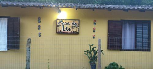马卡埃Casa da Lu的黄色房子的一侧有标志