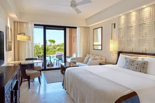 RomanuThe Romanos, a Luxury Collection Resort, Costa Navarino的一间带大床的卧室和一间客厅