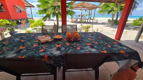 提克豪Tikehau HereArii Airbnb的沙滩上的桌子和鞋