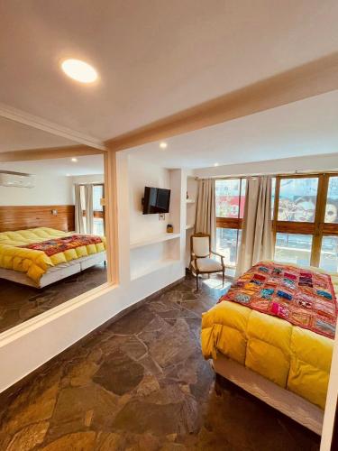 巴拉那Peatonal Suites Paraná的一间带两张床的卧室和一台电视