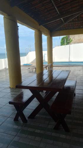 考卡亚Casa Beira Mar - Praia Icaraí - CE的木桌和长凳,位于亭子下