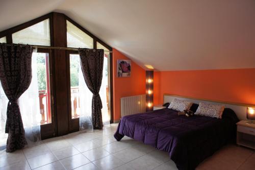 奥尔迪诺拉普朗达酒店的一间卧室设有紫色的床和大窗户