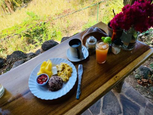 Santa CruzEco-Lodge El Porvenir.的木桌上的早餐盘