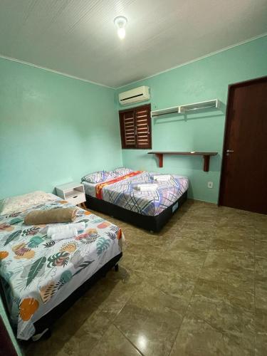 帕里普埃拉Casa de praia Amarópolis的蓝色墙壁客房的两张床