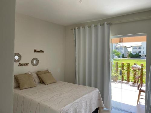 埃斯坦西亚Casa Térrea - Villa das Águas - Praia do Saco的卧室配有一张床,享有庭院的景色