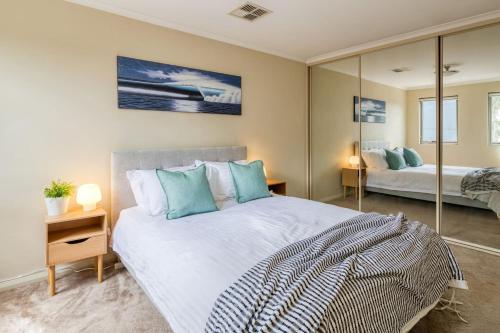 珀斯The Stirling - Experience the Sea to City Lifestyle的一间卧室配有一张大床和镜子