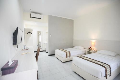 日惹卡克拉库苏马酒店的酒店客房设有两张床和电视。