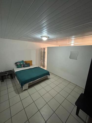 MatouryL'escale de Paramana Ouest的一间位于客房内的带绿床的卧室